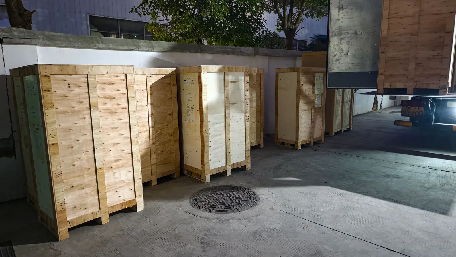 Export timber cases positioned beside a truck for EV charging equipment dispatch