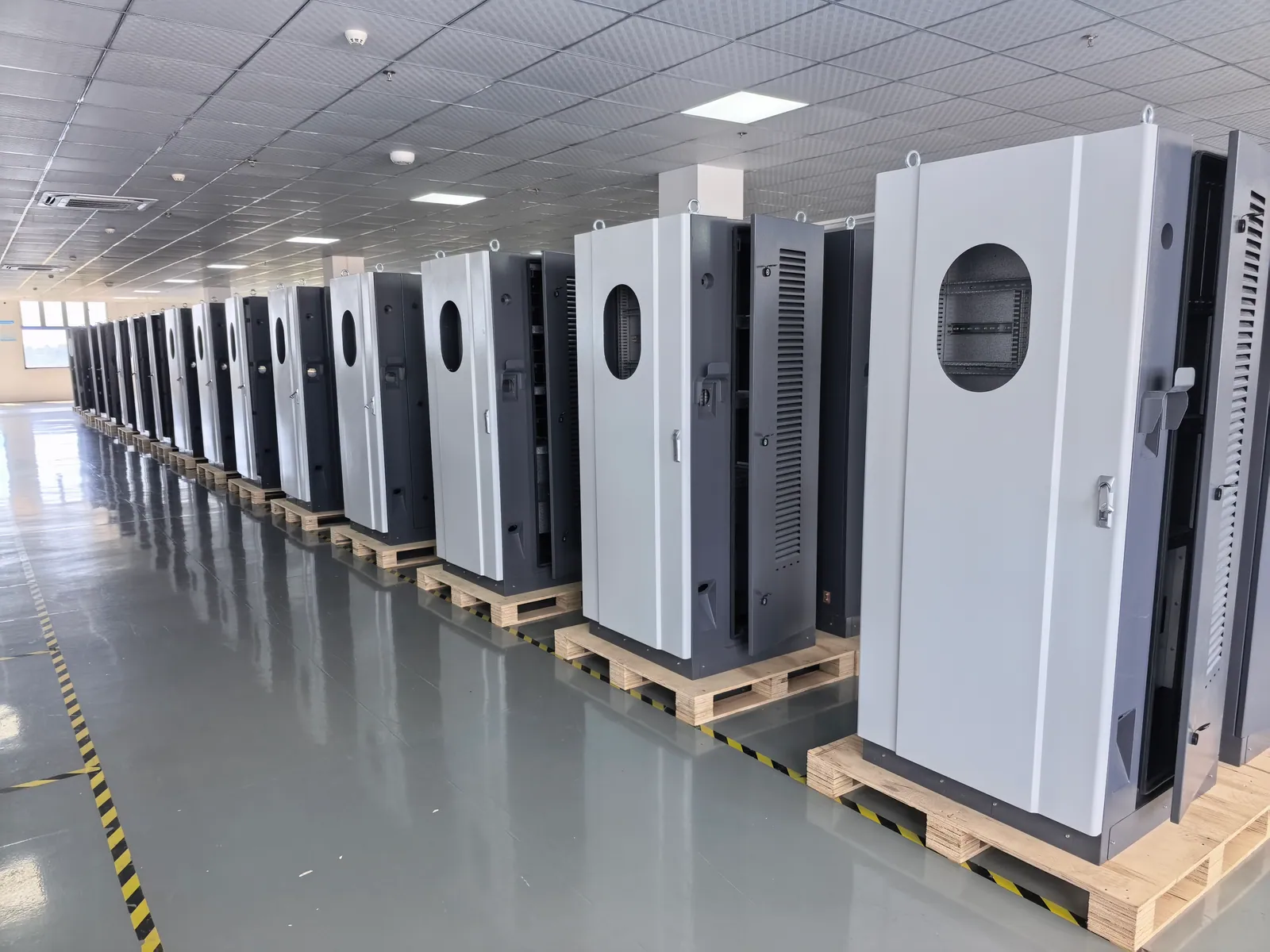 Finished EV charger cabinets lined up for final checks in a production workshop